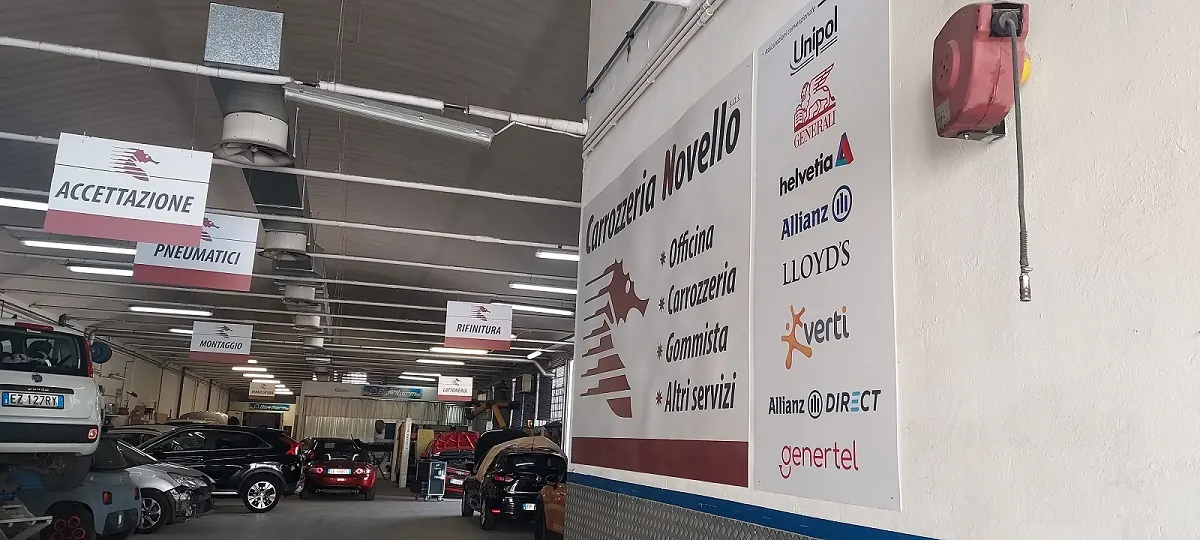 L’interno della Carrozzeria Novello con l’insegna e le auto in lavorazione